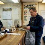 Man exchanging pounds for dollars at counter