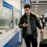 UK traveller checking exchange rates at airport