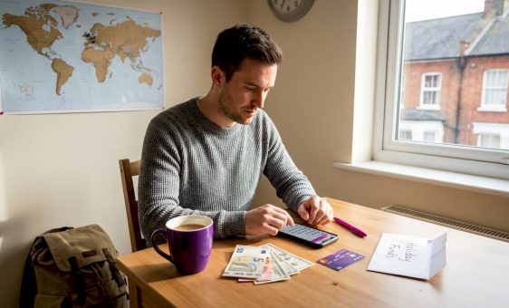 Man picking travel currencies at kitchen table