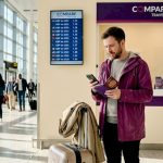Traveler checking exchange rates at airport desk