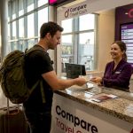 Traveler exchanging foreign currency at airport counter