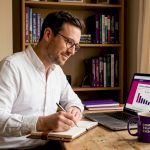 Man comparing exchange rates at home office desk