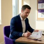 Professional reviewing currency security report at home office
