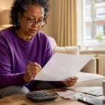 Woman reviewing travel insurance at home table