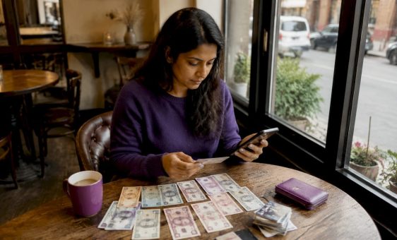 Woman organizing travel money at kitchen table
