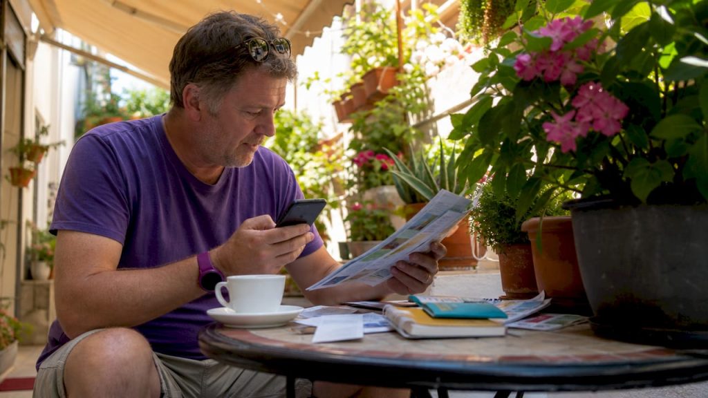 Traveller comparing currency rates at home