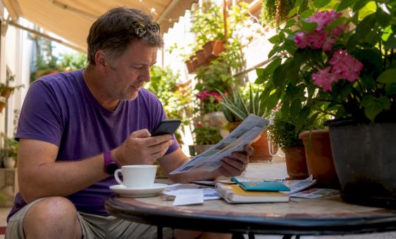 Traveller comparing currency rates at home