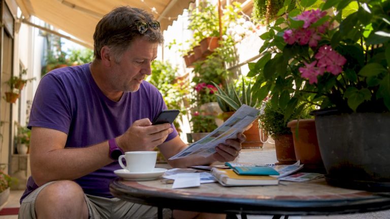 Traveller comparing currency rates at home