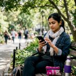 Woman traveler checking currency rates outdoors